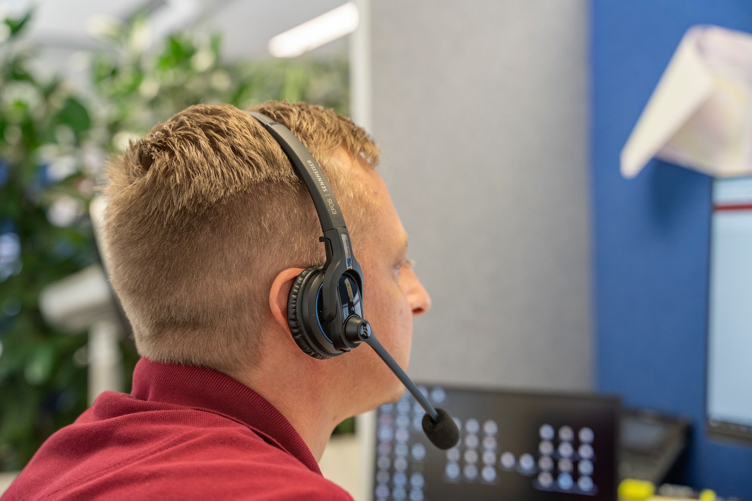 peoplefone Mitarbeiter sitzt mit Headset vor PC und führt eine Videokonferenz durch.