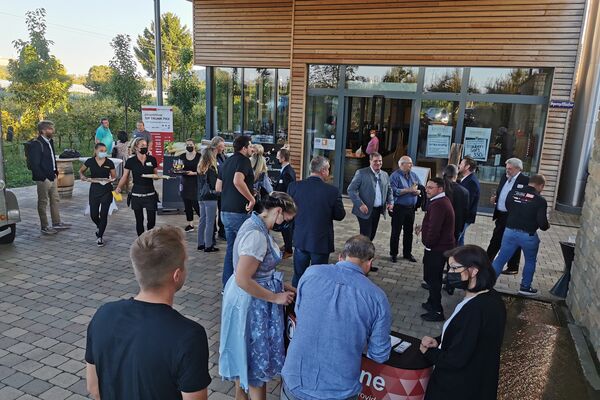 peoplefone Partner bei der Registrierung im Hof des Veranstalters. Im Hintergrund ein Sektempfang.