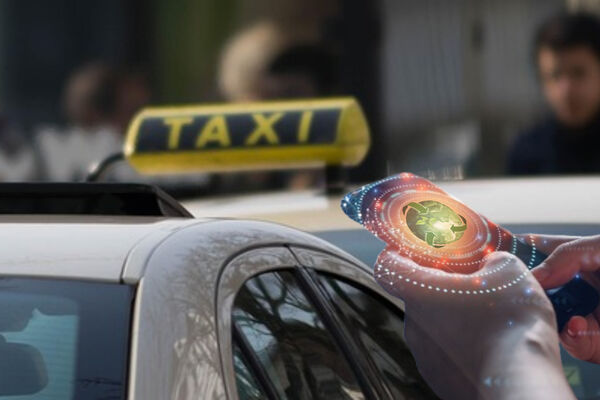 Eine Hand hält ein Handy in Richtung Taxi und gibt Daten ein.