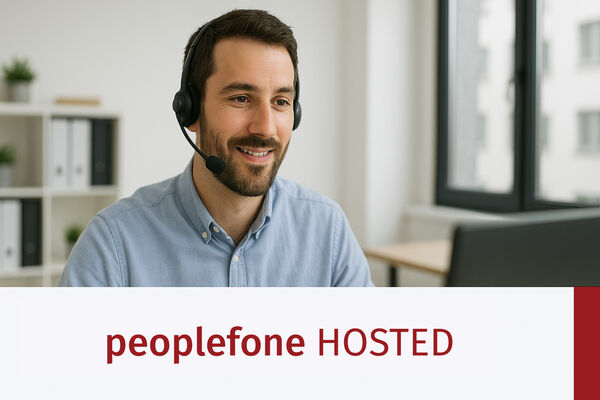 Männliche Person mit Headset sitzt vor einem PC im Office.