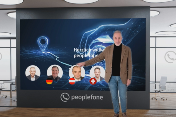 Eine Person steht vor einer Präsentationswand und zeigt auf eine abgebildete Folie.