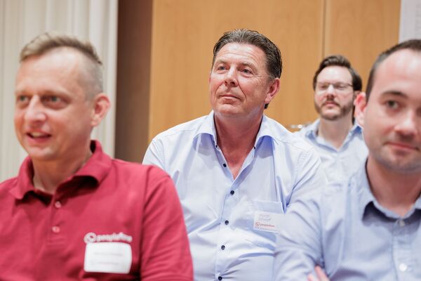 Personen sitzend hören einem Vortrag zu.