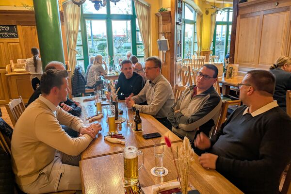 Mehrere Personen sitzen am Stammtisch und unterhalten sich.