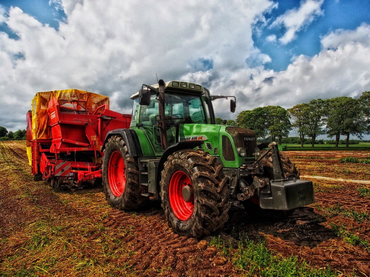 Traktor mit Mähdrescher auf einem Feld.