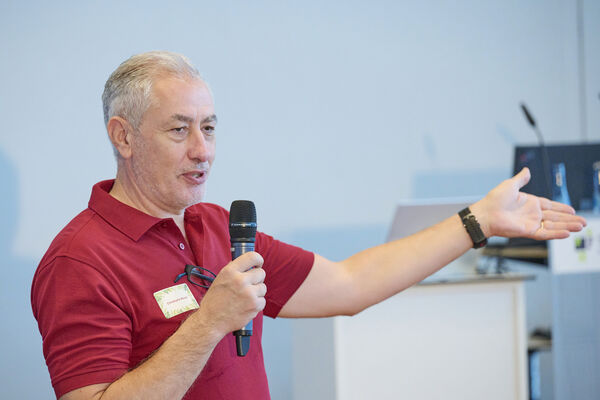 Christophe Beaud steht vor der Bühne und begrüßt die Gäste