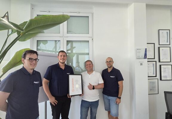 Vier Personen bei Layer7 bei einer Urkundenübergabe.