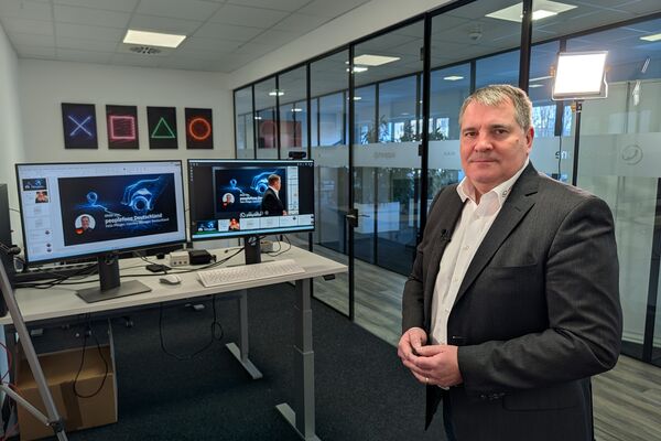 Felix Pflüger im Büro in Fellbach vor zwei Bildschirmen.