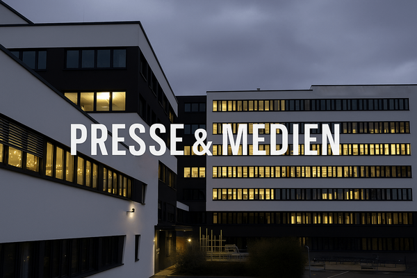 Firmengebäude am Abend. Weiße Schrift im Vordergrund mit Presse & Medien.