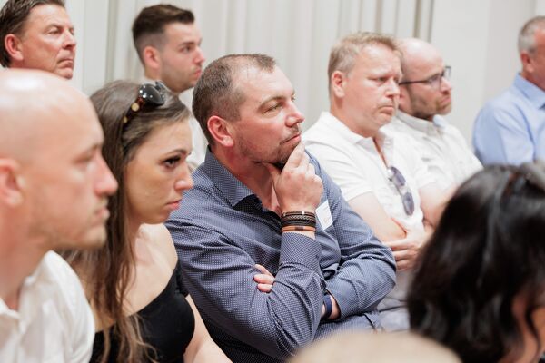 Ausschnitt von Personen im Publikum eines Vortrags.