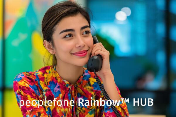 Weibliche Person mit bunter Bluse telefoniert im Office.