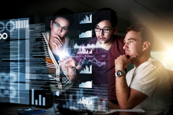 Drei Personen schauen sich Statistiken in 3D an.
