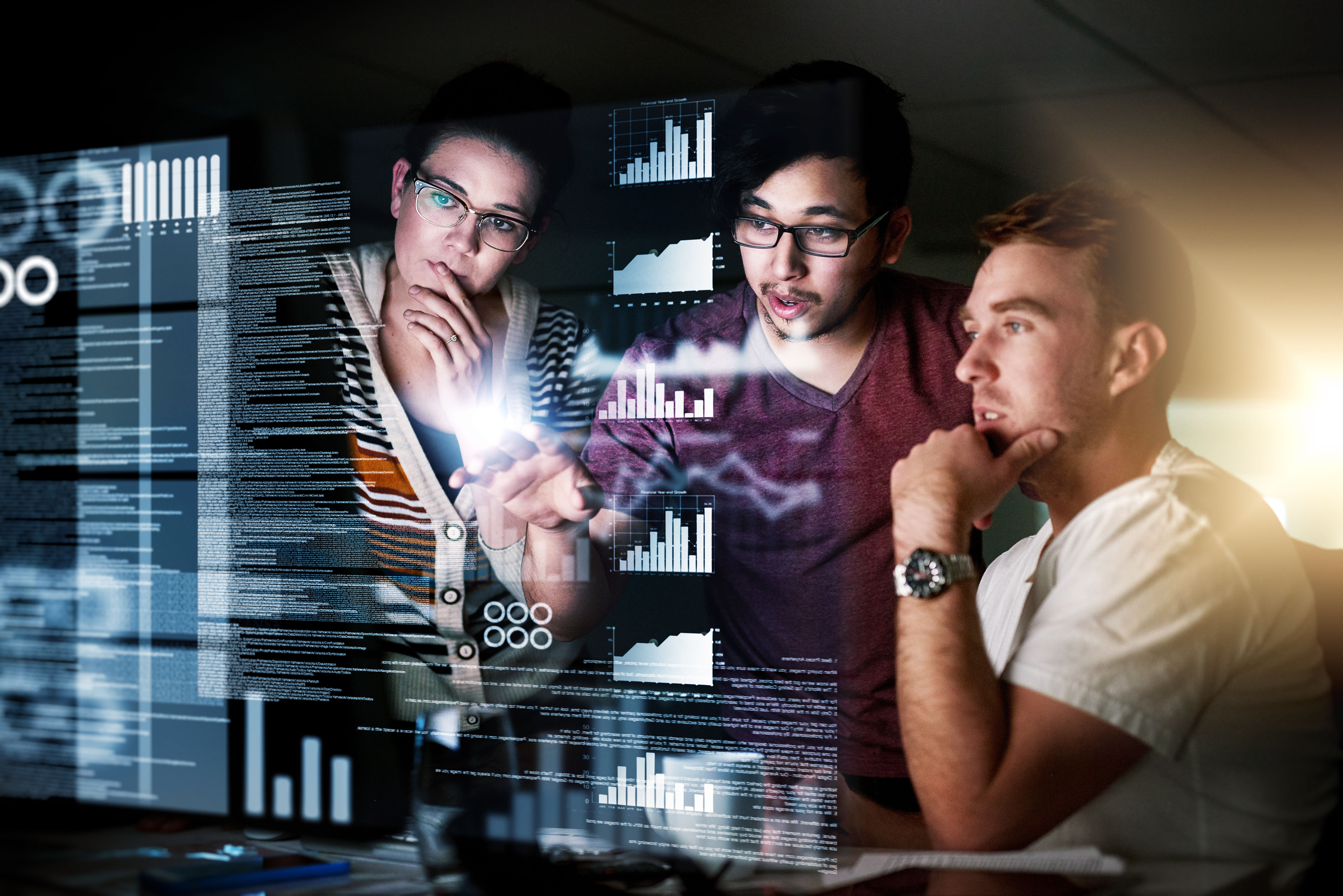 Drei Personen schauen sich interaktive Grafiken an. Der Bildschirm ist transparent und die Personen stehen dahinter.