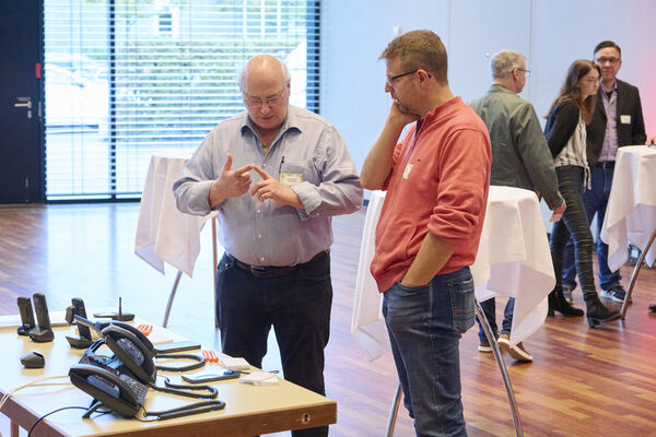 Personen stehen am Messestand und unterhalten sich.