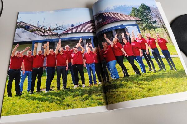 Aufgeschlagenes Heft mit Foto vom Team der peoplefone.