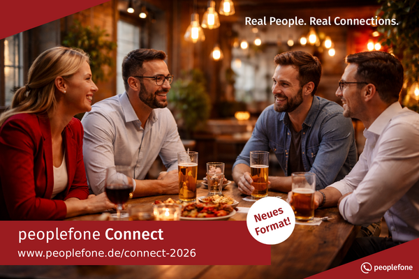 peoplefone Connect Münster. Personen sitzen an einem Holztisch und unterhalten sich.