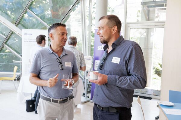 Zwei Personen stehen im Foyer und unterhalten sich.