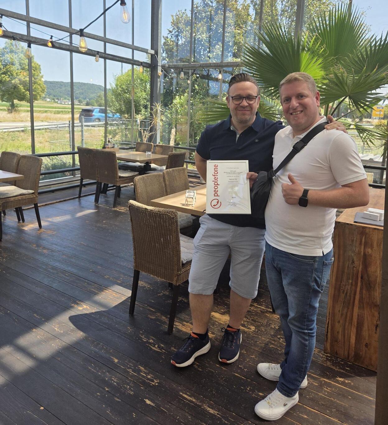 Übergabe Urkunde in einem Glasanbau der Firma regiotec.