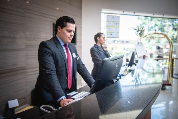 Zwei Personen hinter einer Hotel Rezeption.