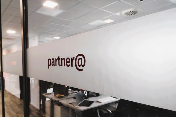 Glaswand mit Aufschrift partner@