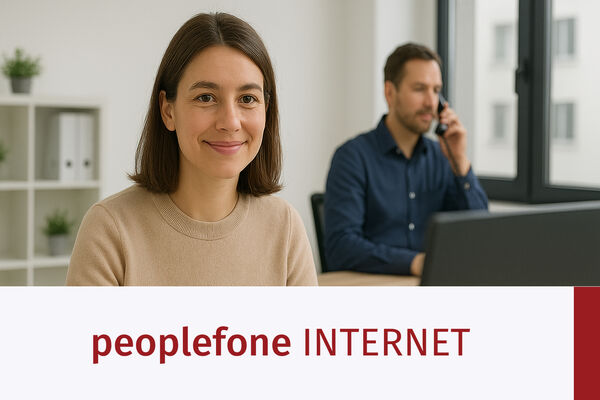 Weibliche Person sitzt vor einem PC im Office. Im Hintergrund sitzt eine männliche Person am Telefon.