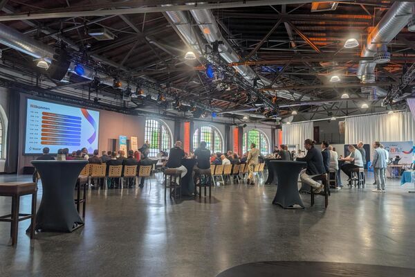 Messehalle mit Bestuhlung und Leinwand.
