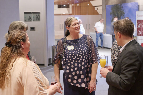 Personen stehen im Raum zusammen und reden.