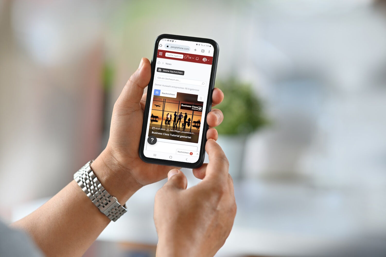 Zwei Hände halten ein Handy. Auf dem Bildschirm ist die Seite der businessclass abgebildet.