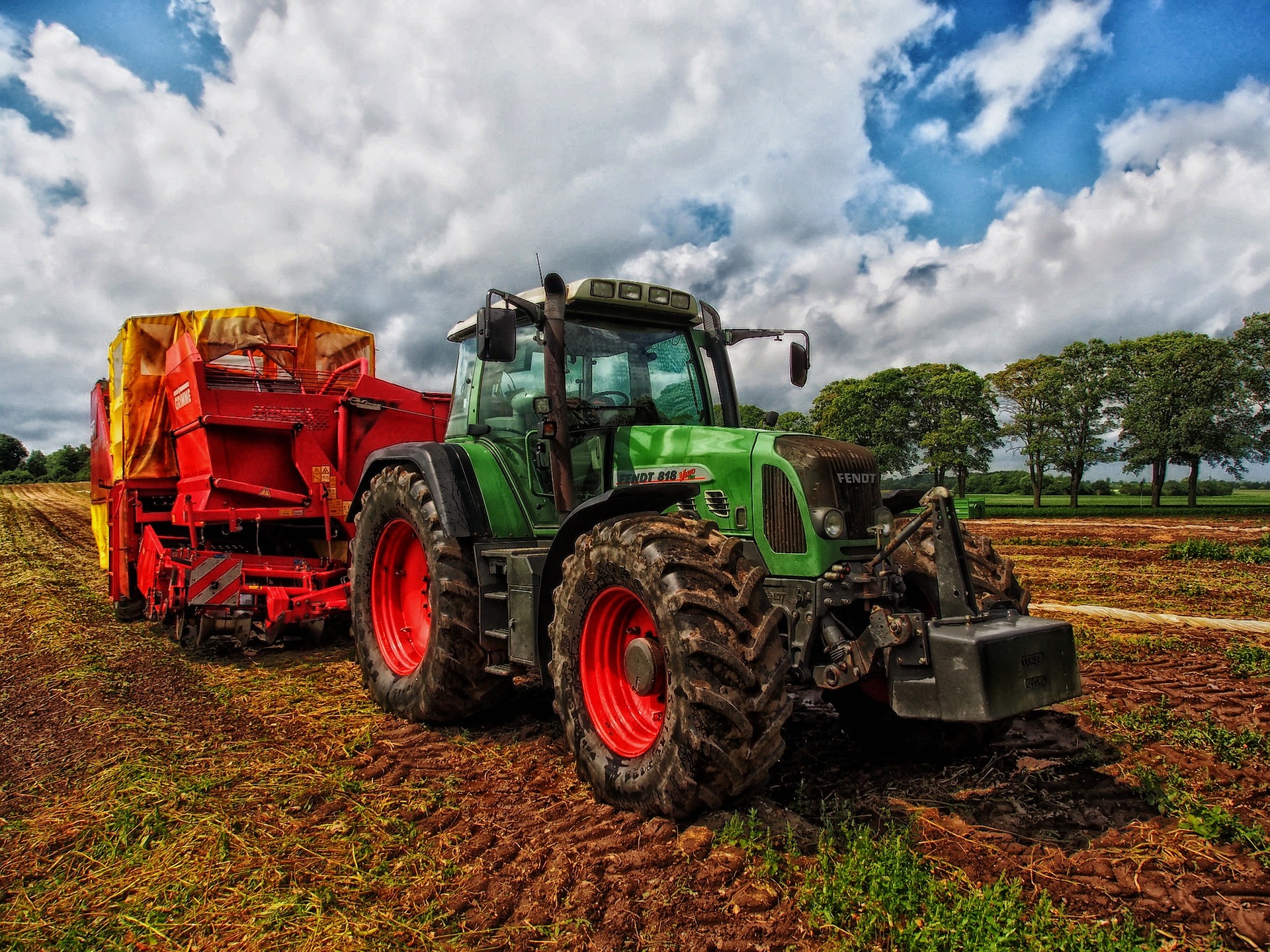 Traktor mit Mähdrescher auf einem Feld.
